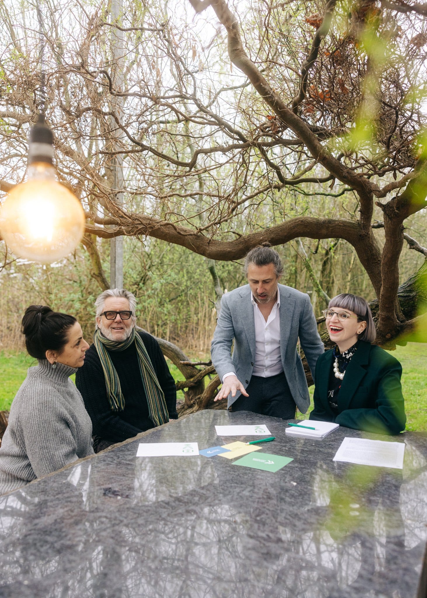 Team van Amazing Cultures aan tafel in een groene omgeving, bespreekt innovatieve strategieën